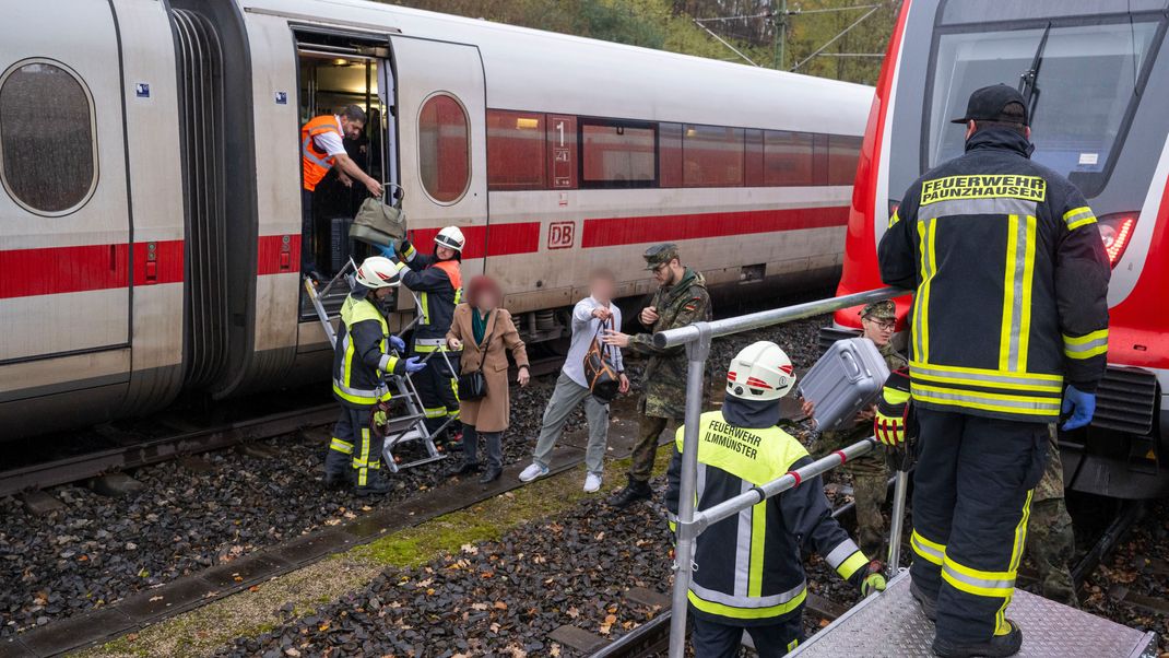 Nach dem Unfall werden die Fahrgäste des ICE von Rettungskräften evakuiert. 