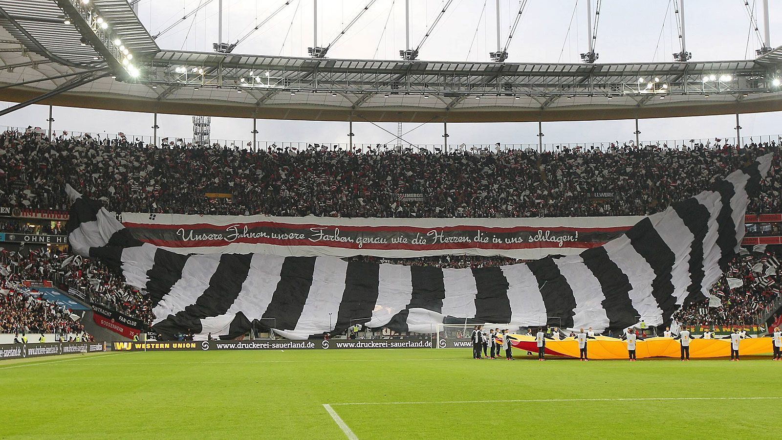 
                <strong>Heimspiel gegen Girondins Bordeaux (19. September 2013)</strong><br>
                Vor dem 3:0 im Auftaktspiel gegen die Franzosen rauschte ein überdimensionales schwarz-weißes Banner über die Fans hinweg. Dazu wurde das Motto "Unsere Fahnen, unsere Farben, genau wie die Herzen, die in uns schlagen!" präsentiert.
              