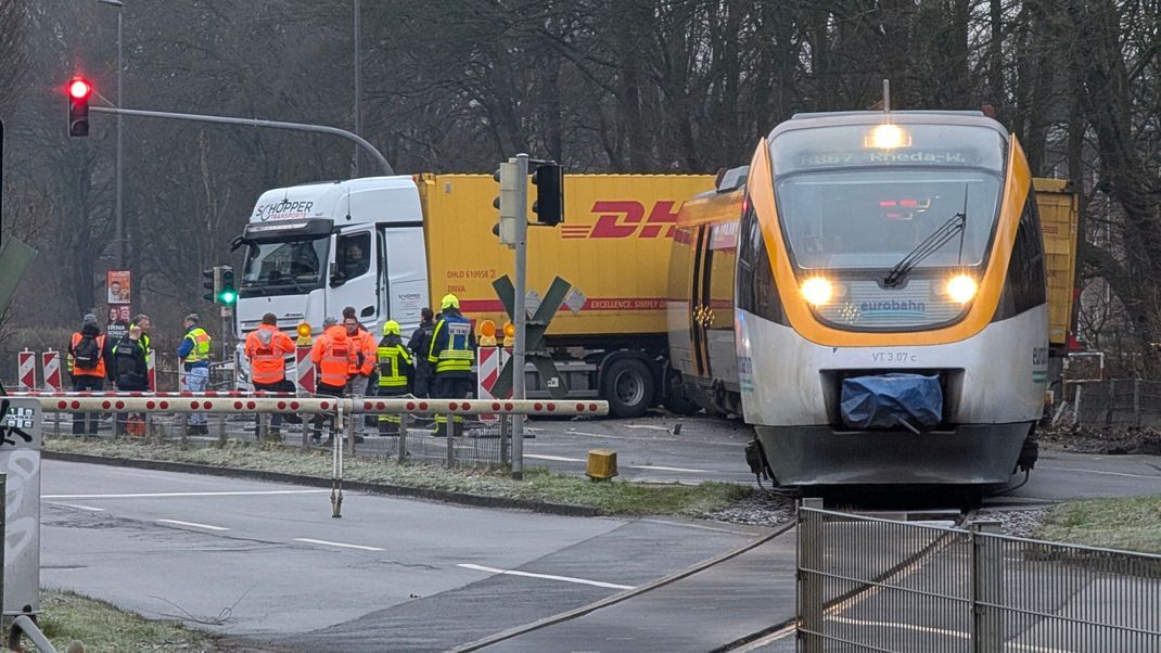 Rettungskräfte sind nach einem Zusammenstoß zwischen einem Regionalzug und einem Lkw im Einsatz. 