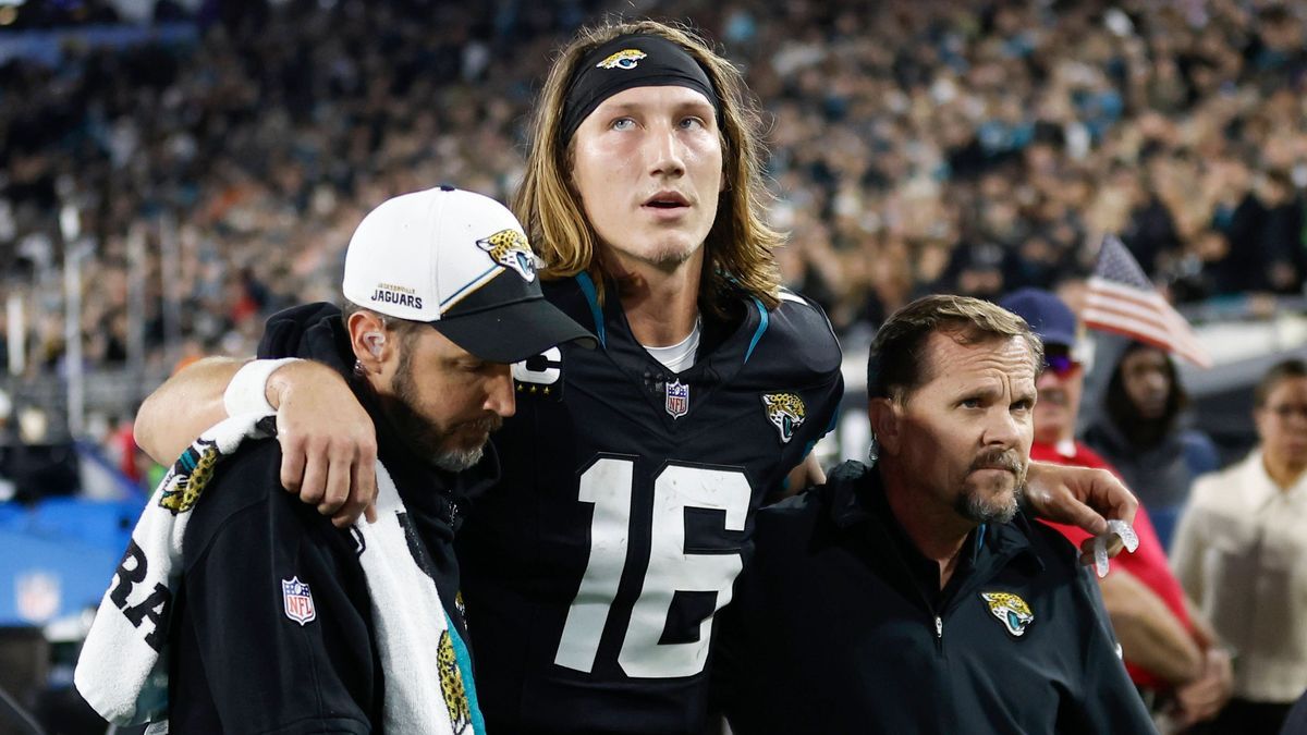 JACKSONVILLE, FL - DECEMBER 04: Jacksonville Jaguars quarterback Trevor Lawrence (16) is helped off the field by training staff during the game between the Jacksonville Jaguars and the Cincinnati B...