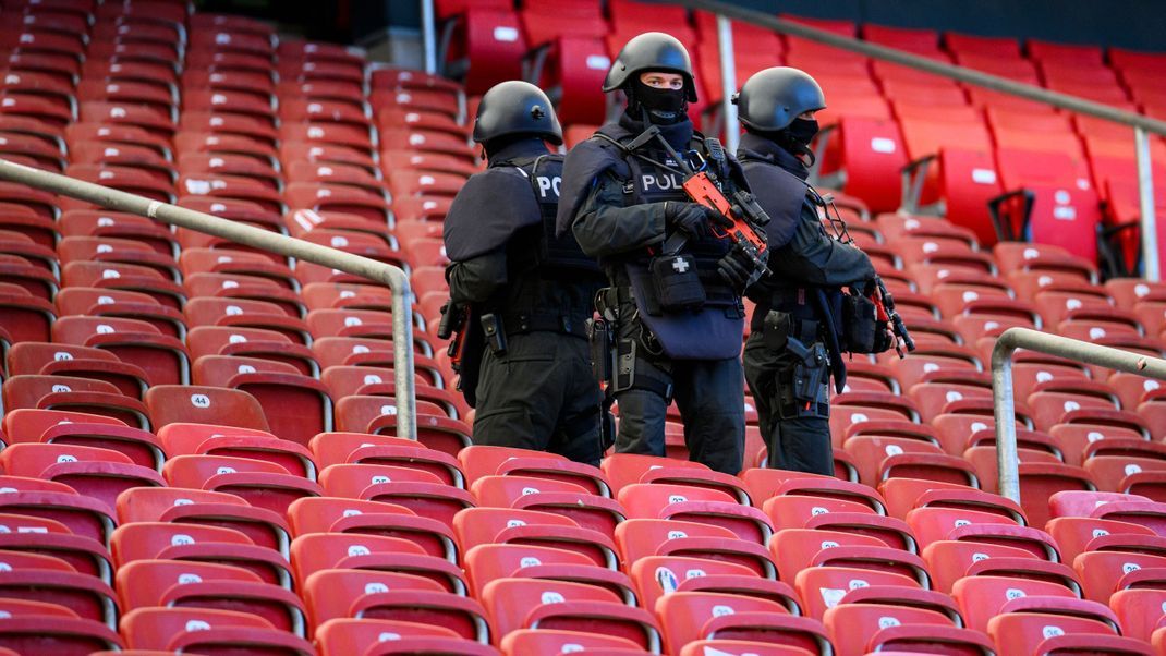 Polizisten stehen bei einer praktischen Übung einer Einsatzlage zur Fußball-Europameisterschaft in der MHP Arena.