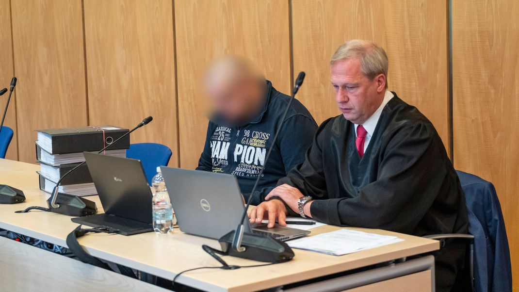 Der Angeklagte (l) sitzt neben Michael Linke (r), Rechtsanwalt zu Beginn des Prozesses wegen Mordes an einer 40-Jährigen aus Coburg.