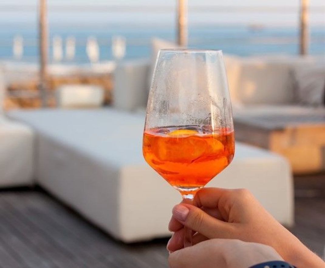 Urlaubs-Feeling im Glas: Ein Aperol Spritz ist auch Zuhause ganz schnell zubereitet und beamt uns beim Schlürfen gedanklich an den Strand oder Pool.