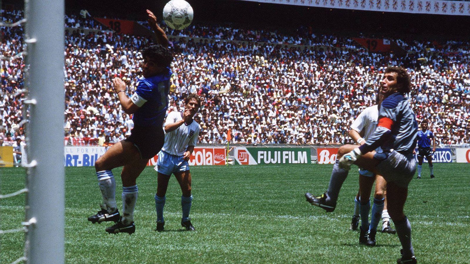 
                <strong>Die Hand Gottes</strong><br>
                Die "Hand Gottes"! Im selben Spiel beförderte Maradona den Ball regelwidrig mit der geballten Faust über den englischen Keeper Peter Shilton ins Tor. Der Schiedsrichter sah es nicht, das Tor zählte und ging in die Geschichte ein. "Es war der Kopf Maradonas und die Hand Gottes", sagte der Superstar nach dem Spiel. Der 22. Juni ist heute noch als Tag des Fußballs in Argentinien bekannt.
              