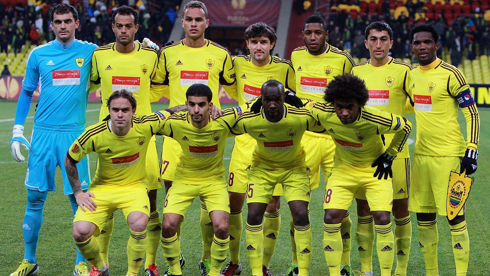 
                <strong>Anzhi Makhachkala (Russland)</strong><br>
                Als der russische Oligarch Suleiman Kerimov den bis dahin unbekannten Klub Anzhi Makhachkala aus der Teilrepublik Dagestan 2011 erwarb, horchte die Fußballwelt auf. Denn der Milliardär hatte große Pläne, wollte Anzhi in die Champions League führen und verpflichtete Stars wie Samuel Eto'o (rechts oben), Willian (rechts unten) oder Lassana Diarra (vorne, links neben Willian). Zunächst war das Projekt erfolgreich, der Verein schaffte es in die Europa League - doch dort begannen die Probleme. Aufgrund politischer Unruhen musste Anzhi Makhachkala seine Europapokal-Heimspiele in Moskau austragen, wo die Spieler auch sonst trainierten und nur zu Liga-Heimspielen in Makhachkala eingeflogen wurden. Gut 31 Monate nach seiner Übernahme musste sich Kerimov eingestehen, dass seine Idee gescheitert war. Seitdem spielt der Verein mit größtenteils unbekannten Akteuren und Talenten gegen den Abstieg aus der Premier Liga.
              