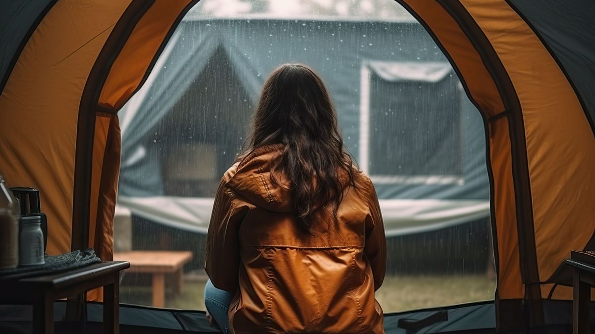 Woman sitting in tent while raining, camping (Ai generated)