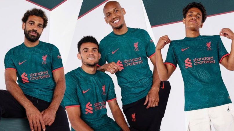 
                <strong>FC Liverpool Ausweichtrikot 2022/23</strong><br>
                Der FC Liverpool hat sein drittes und finales Trikot für die Saison 2022/23 vorgestellt. Mohamed Salah, Luis Diaz und Co. weichen künftig in dunklem Grün aus. Wappen, Sponsoren und Logos sind hingegen in "Neonrot" gehalten - genauso wie die Elemente an den Ärmeln. Das Trikot - das vor allem auch in der Champions League zum Einsatz kommen wird - ist eine Hommage des Klubs an die Unterstützung der Fans bei europäischen Auswärtsspielen über die vergangenen Jahrzehnte.
              