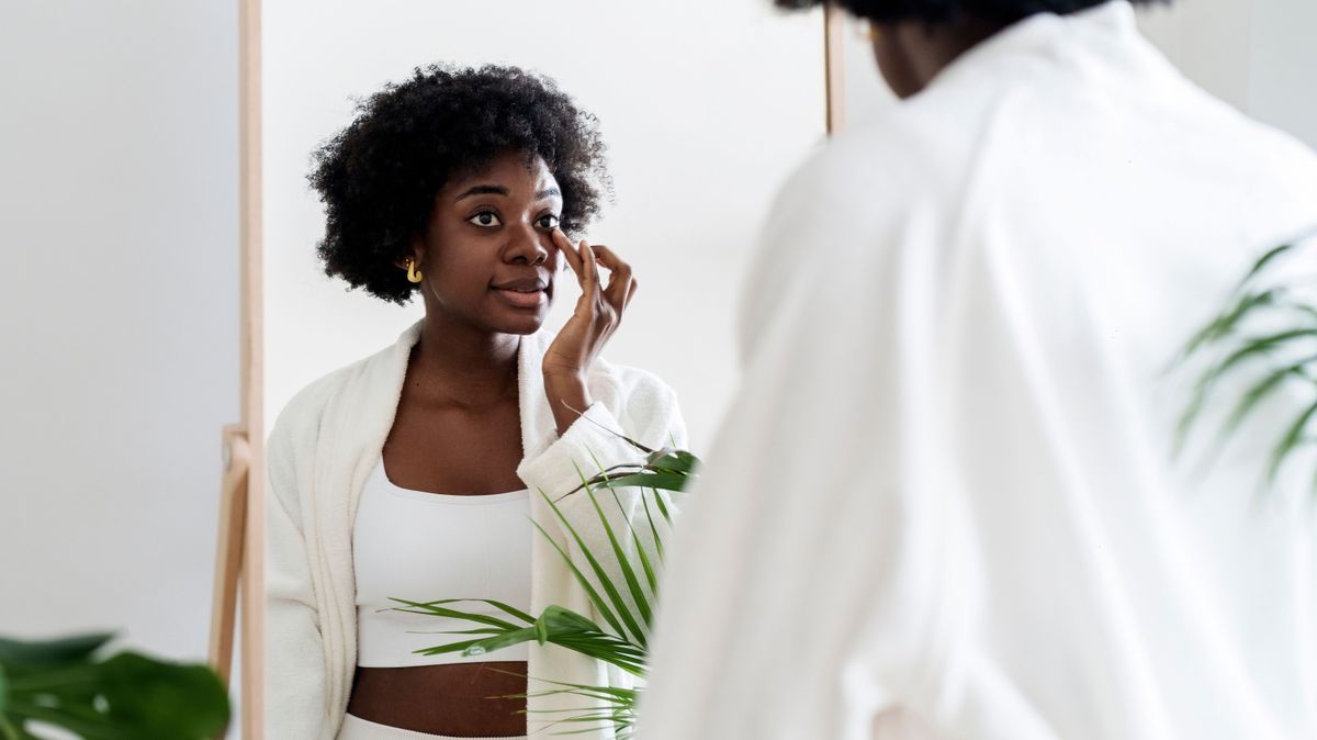 Woman applying moisturizer under eyes