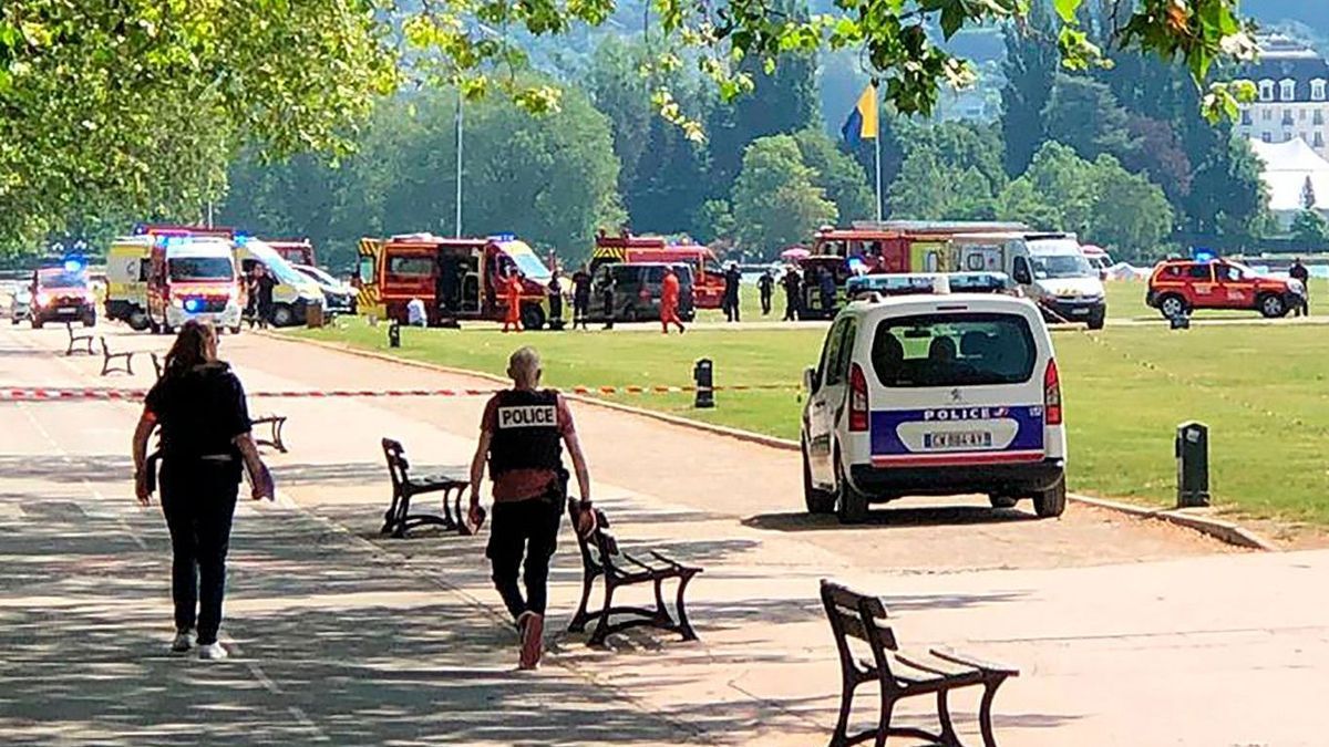 Polizisten und Rettungskräfte gehen nach einem Messerangriff in einem französischen Park zum Tatort. 