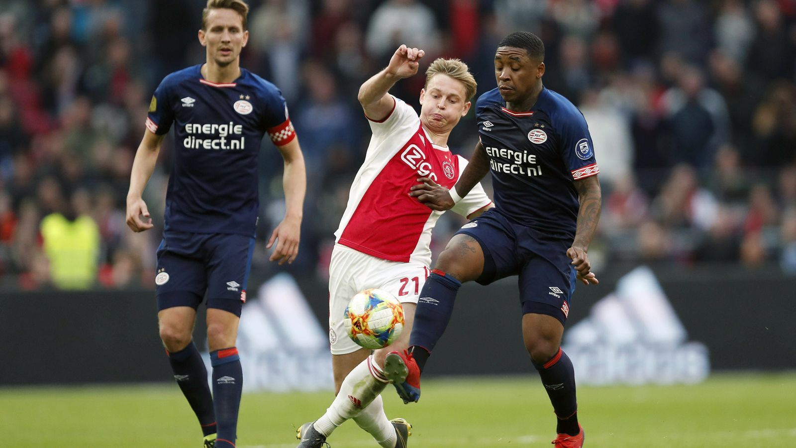 
                <strong>Eredivisie (Niederlande)</strong><br>
                Ajax Amsterdam um den künftigen Barca-Star Frenkie de Jong (Mi.) hat die Meisterschaft in den Niederlanden zuletzt wieder richtig spannend gemacht. Der Hauptstadt-Klub gewann mit 3:1 gegen Tabellenführer PSV Eindhoven und liegt damit bei noch sechs verbleibenden Spielen mit 65 Punkten nur mehr zwei Zähler hinter dem Titelverteidiger der Eredivisie. Die PSV von Trainer Mark van Bommel wird im Saison-Endspurt wohl weiterhin auf die Treffsicherheit von Topstürmer Luuk de Jong (li.) setzen. Der frühere Gladbacher hat schon 22 Saisontore auf dem Konto und führt die Torschützenliste der Eredivisie an.
              