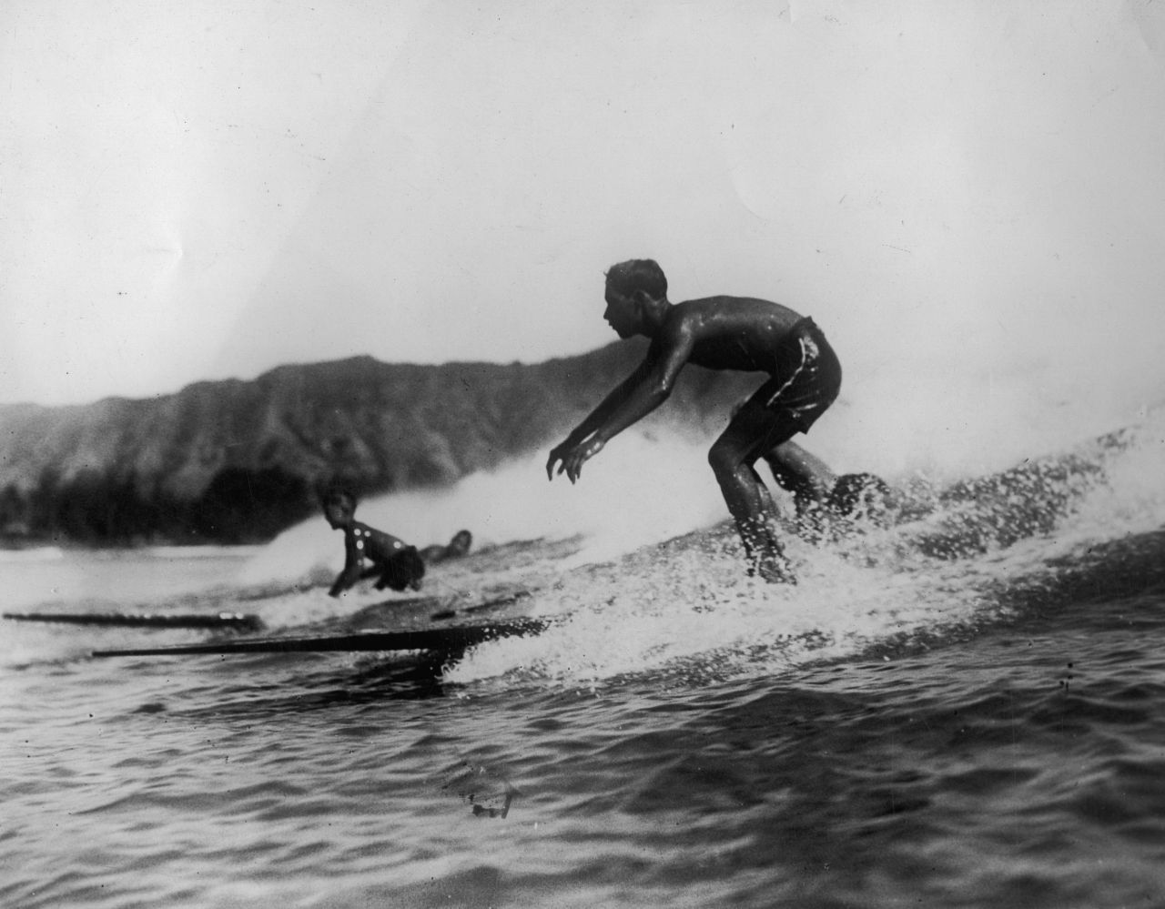 Mit der Seefahrt gelangte das Wellenreiten von Polynesien um 1720 nach Hawaii. Für die Hawaiianer:innen war es mehr als ein Hobby: Der Bau eines Surfbretts ging mit religiösen Ritualen einher, um sich den Schutz und das Wohlwollen der Götter zu sichern. Und das Holz musste vom "richtigen" Baum stammen. Im Zuge der Missionierung jedoch wurde das Surfen 1823 verboten - aber es verschwand niemals ganz. Als 1908 der erste Surf-Cl