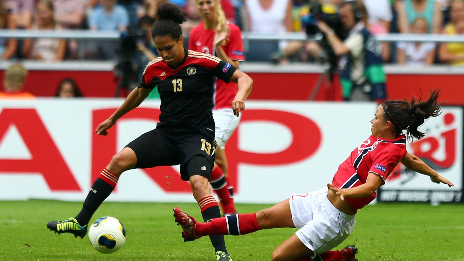 
                <strong>Celia Okoyino da Mbabi</strong><br>
                Das Halbfinale verpasste die Stürmerin noch aufgrund einer Oberschenkelverletzung. Im Endspiel war die deutsche Mittelstürmerin zurück und bereitete das 1:0 zum Turniersieg vor. 2015 beendete Okoyino da Mbabi, die inzwischen unter dem Namen Sasic bekannt ist, ihre Karriere und ist heute die Vizepräsidentin des Deutschen Fußball-Bundes für Diversität und Vielfalt. 
              