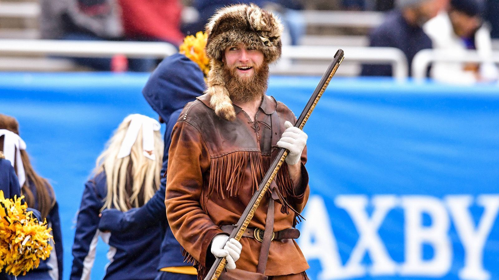 
                <strong>West Virginia Mountaineer...</strong><br>
                Der "Bergsteiger" ist das offizielle Maskottchen der Universität und er trägt traditionell seit 1930 eine Uniform aus Hirschleder. Das eigens aufgestellte "Mountaineer Selection Committee" wählt dafür Studenten aus, die ganz besonders gute akademische Leistungen zeigen, einen guten Charakter haben und Enthusiasmus für die Universität und für die Community zeigen. Eine Besonderheit: das Kostüm wird jedem Gewinner dieser Wahl auf den Leib geschneidert. Es ist auch Tradition, wenn auch nicht zwingend notwendig, dass sich der Erwählte einen Bart wachsen lässt, solange seine "Amtszeit" läuft.
              