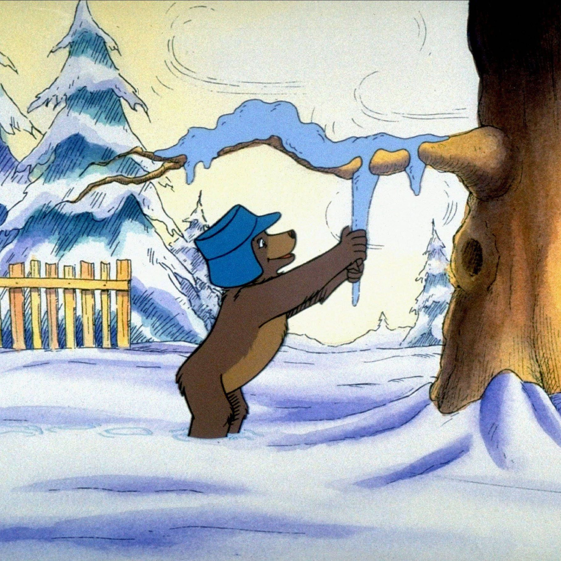 Der kleine Bär zeiht an einem Eiszapfen in einem verschneitem Wald.