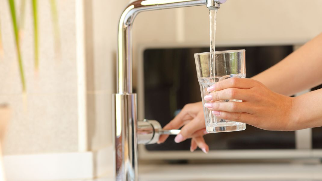 Woman hands filling a glass of tap water