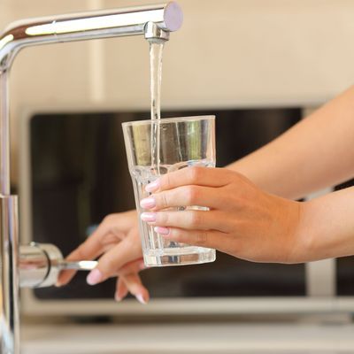 Woman hands filling a glass of tap water