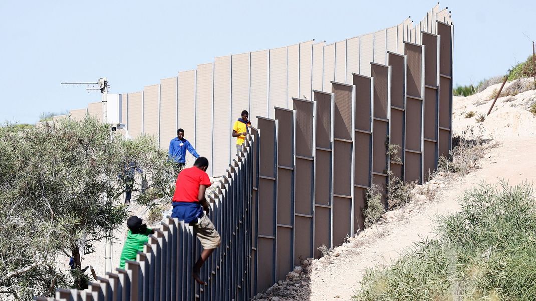 Migranten klettern über einen Zaun auf der Insel Lampedusa. Um eine irreguläre Migration in der EU zu unterbinden, werde es demnächst Verschärfungen der bisherigen Regeln geben.&nbsp;