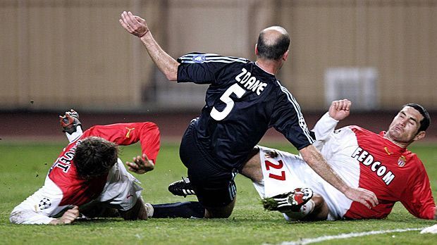 
                <strong>AS Monaco gegen Real Madrid 2003/2004</strong><br>
                AS Monaco gegen Real Madrid 2003/2004: Endstation Viertelfinale heißt es auch für die mit Superstars wie Zinedine Zidane (Mi.), Luis Figo, David Beckham und Ronaldo gespickten Madrilenen. Zu Hause nehmen die "Königlichen die Monegassen mit 4:2 auseinander - ausgerechnet der langjährige Real-Stürmer Fernando Morientes verkürzt kurz vor Schluss. Das rächt sich: Monaco gewinnt das Rückspiel trotz Rückstands mit 3:1 - Torschütze unter anderem Morientes - und kommt dank eines mehr erzielten Auswärtstreffers weiter.
              