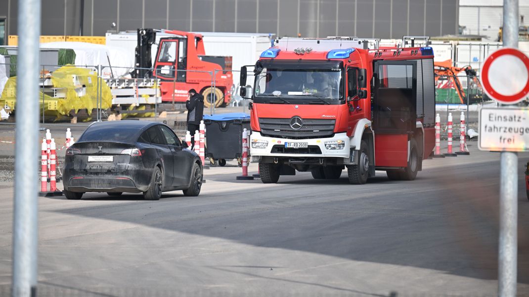 Ein Fahrzeug der Feuerwehr steht auf dem Gelände der Tesla-Autofabrik in Grünheide, wo die Produktion wegen eines Stromausfalls stillsteht.