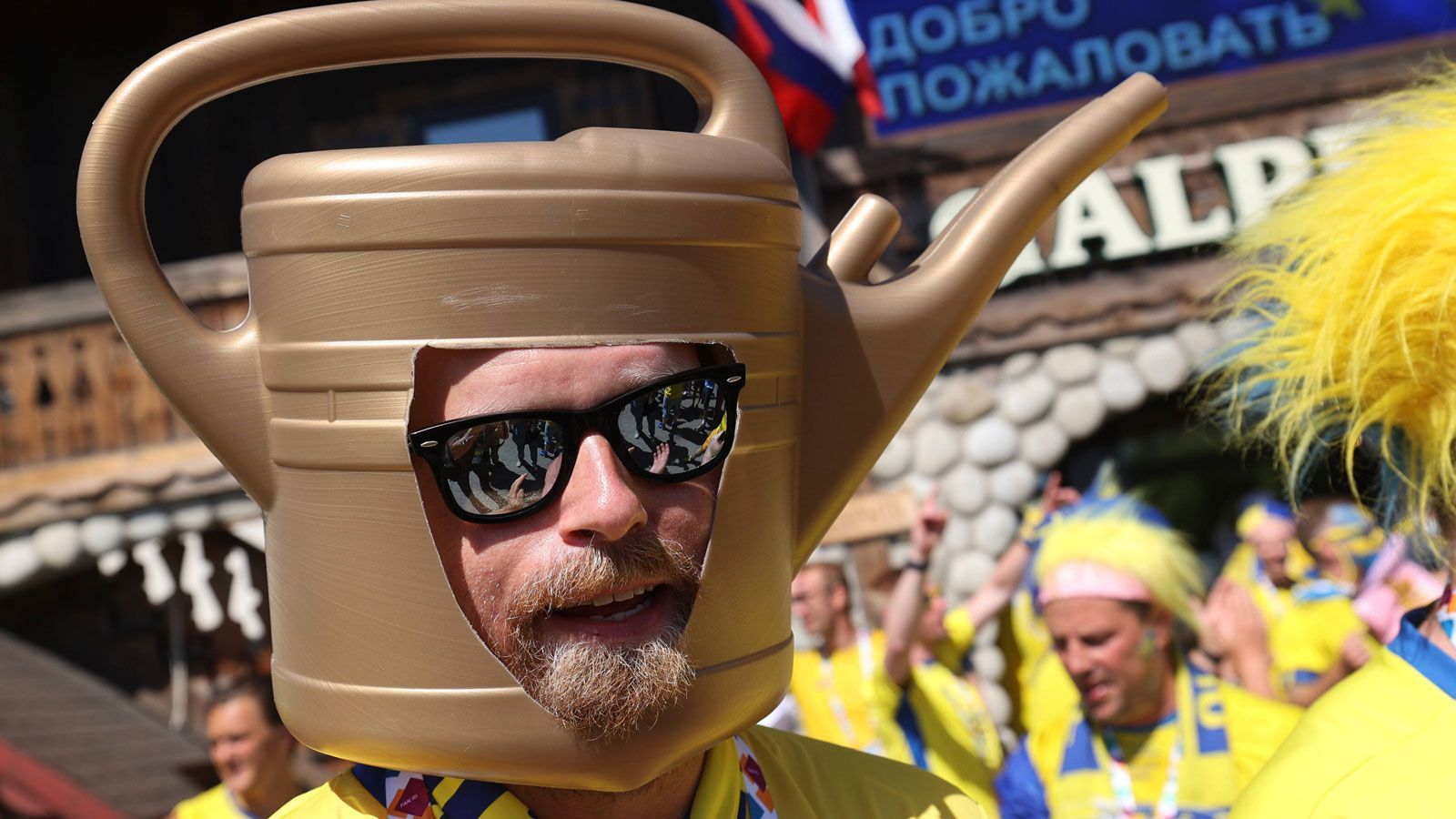 
                <strong>Heute mal als Gießkanne unterwegs</strong><br>
                Eine ganz ausgefallene Verkleidung trug dieser Schweden-Fan zur Schau. Hat man so bislang eher seltener gesehen und einen Kostümwettbewerb gewinnt er damit wohl auch kaum - individuell ist es aber auf jeden Fall.
              