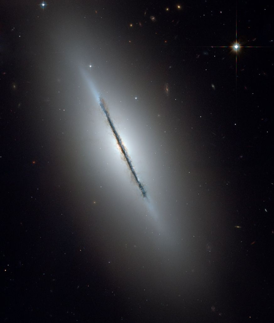 Im Sternbild Drache liegt "Messier 102", rund 44 Millionen Lichtjahre von der Erde entfernt. Die Staub-Bahn des M102 wird auch Spindel-Galaxie genannt: Der helle Kern ist von einer rötlichen Wölbung umgeben. Parallel zur Staub-Bahn verläuft eine Scheibe bläulicher Sterne und ein durchsichtiger Lichtschleier.