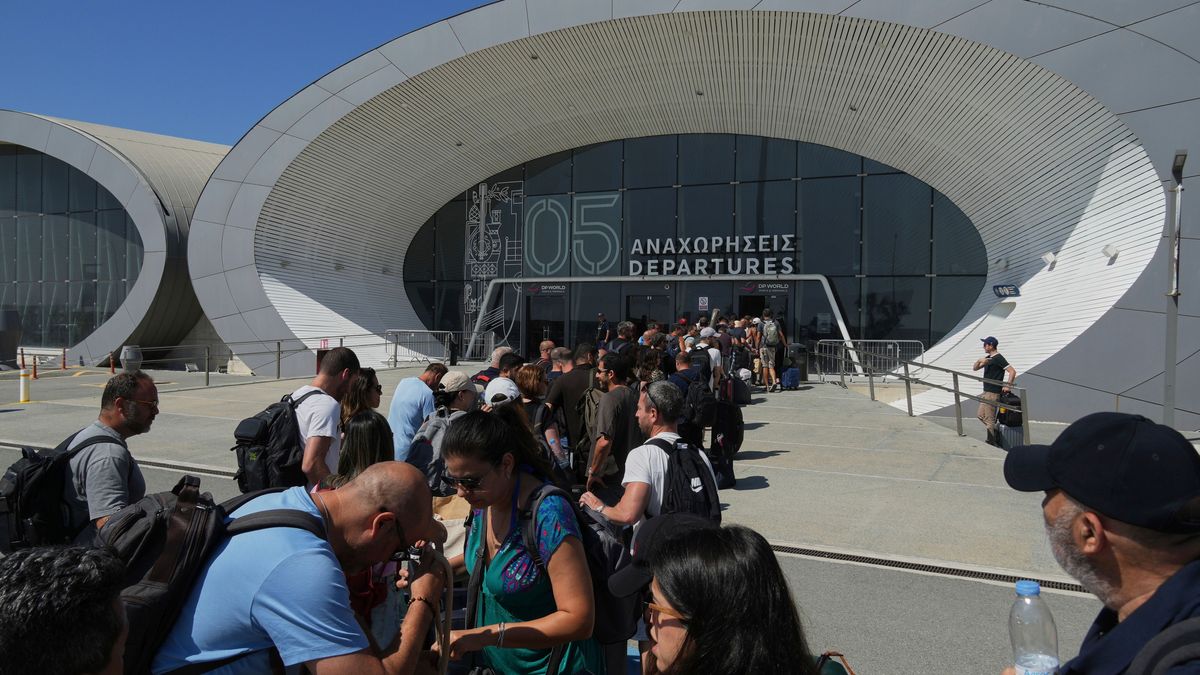 Israelis warten am Eingang zum Abfahrtsterminal des zyprischen Haupthafens in Limassol, um zurück in ihre Heimat zu kehren.