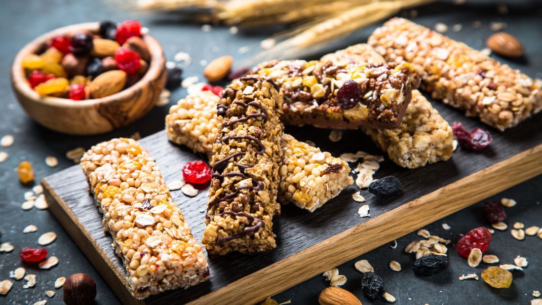 Granola bar with nuts, fruit and berries on black.