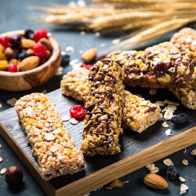 Granola bar with nuts, fruit and berries on black.