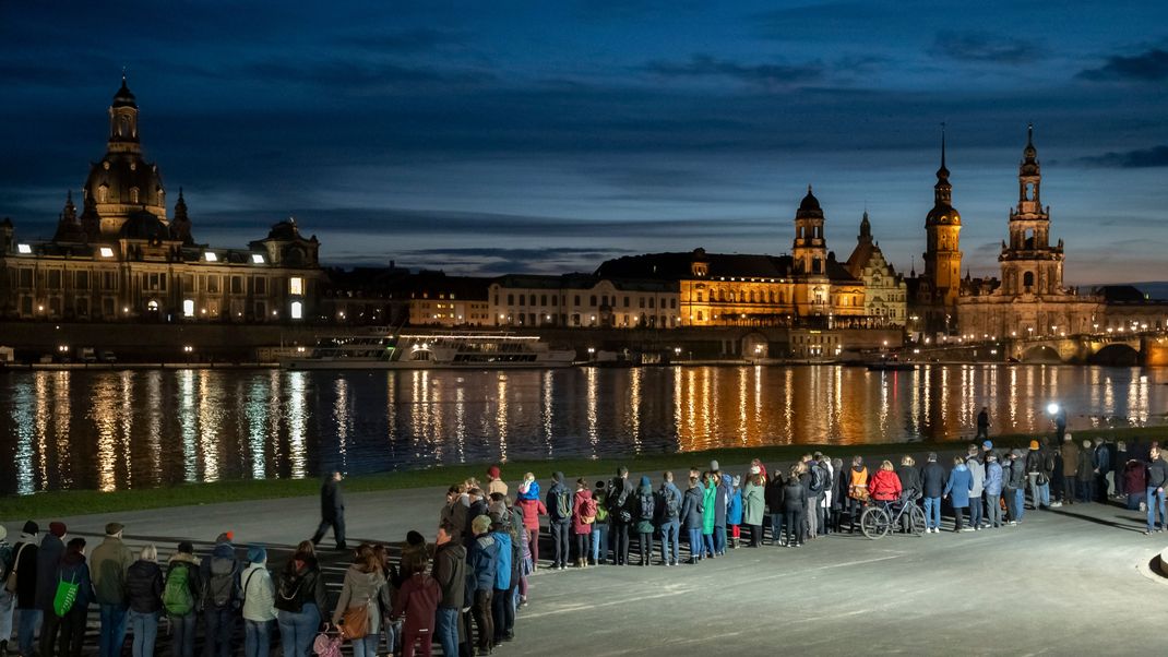 Mehrere tausend Menschen schließen für zehn Minuten eine Menschenkette rund um die Altstadt mit den Glockenschlägen der Dresdner Kirchen um 18 Uhr.