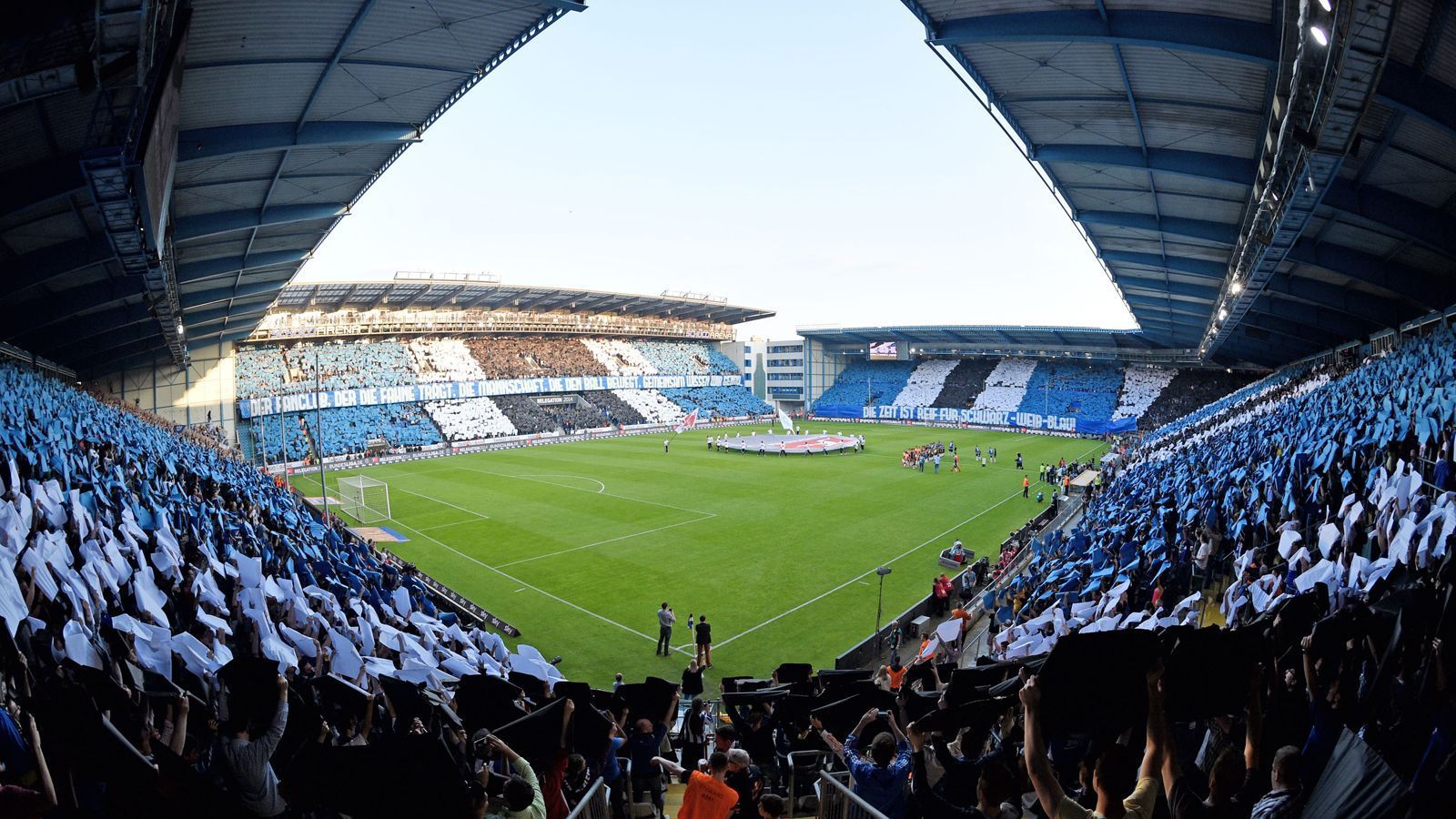 
                <strong>Das Stadion: Die Alm in der Innenstadt</strong><br>
                Die Bielefelder Alm – oder offiziell SchücoArena – ist ein Traum für Fans: 114 Jahre alt, aber nach mehreren Tribünenneubauten dennoch modern, steht das Stadion nicht wie viele moderne Arenen in zugigen Gewerbeparks außerhalb der Stadt, sondern mitten in Bielefeld. Vom Hauptbahnhof sind es gerade einmal 15 Minuten zum Stadion – zu Fuß! Mit dem Fassungsvermögen von 26.515 Plätzen sticht Bielefelds Stadion zudem Absteiger und Nachbar Paderborn (15.000) locker aus.
              