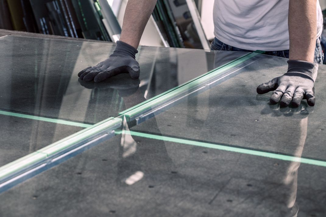 Handwerker bricht Glas auf einem fachgerechten Tisch.