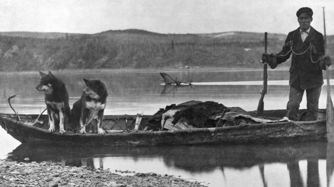 Ein Inuit-Trapper transportiert im Alaska des frühen 20. Jahrhunderts Tierhäute in seinem Kanu.
