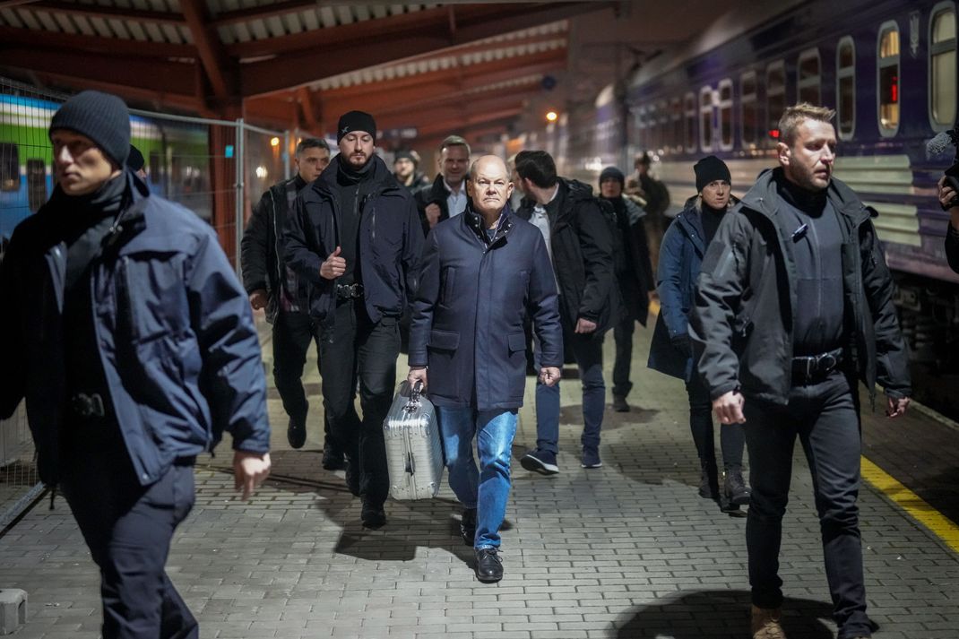 Bundeskanzler Olaf Scholz (SPD, M) geht in Begleitung von Sicherheitskräften auf dem Bahnhof der polnischen Grenzstadt Przemysl zum Sonderzug für die Fahrt in die ukrainische Hauptstadt Kiew.