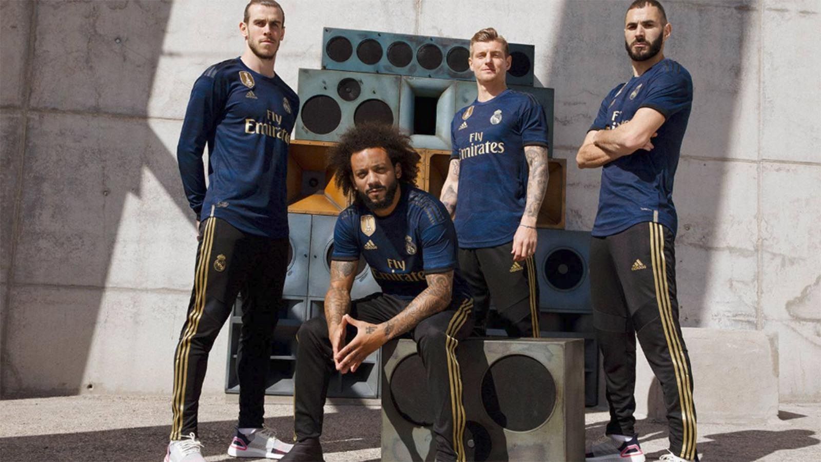 
                <strong>Real Madrid</strong><br>
                Real Madrid hat das Auswärtstrikot für die kommende Saison vorgestellt. In einem extra dafür gedrehten Rapvideo wird die Uniform von Stars wie Toni Kroos, Marcelo oder Karim Benzema vorgestellt. Das Jersey ist in Blau, Gold und Schwarz gehalten. Wie bei dem Heimtrikot (siehe nächstes Bild) sind goldene Streifen eine Hommage an die erfolgreichsten Zeiten der Königlichen. Dazu sind Wellen zu sehen, welche an die Atmosphäre im heimischen Estadio Santiago Bernabeu Stadion erinnern soll. Der Slogan "Create The Noise", unter welchem das Trikot veröffentlicht wurde, ist ebenfalls in das Shirt eingearbeitet. 
              