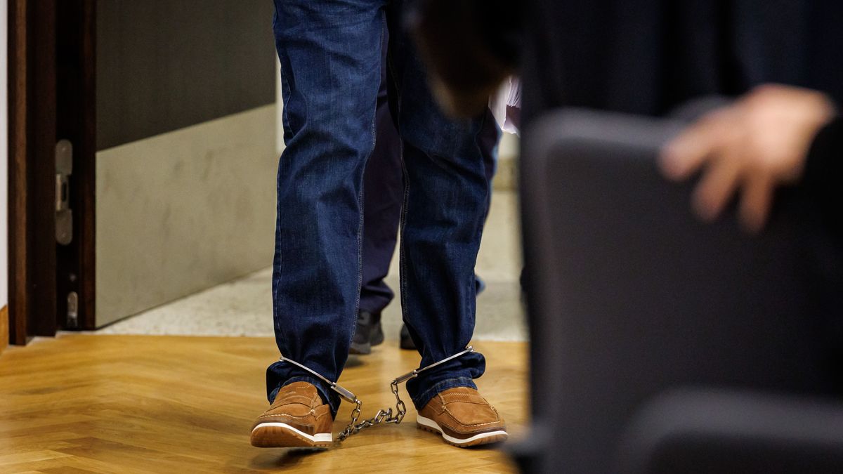 Mit Fußfesseln betritt ein angeklagter Mann zum Prozessbeginn den Sitzungssaal des Strafjustizzentrums des Landgerichts Nürnberg-Fürth.