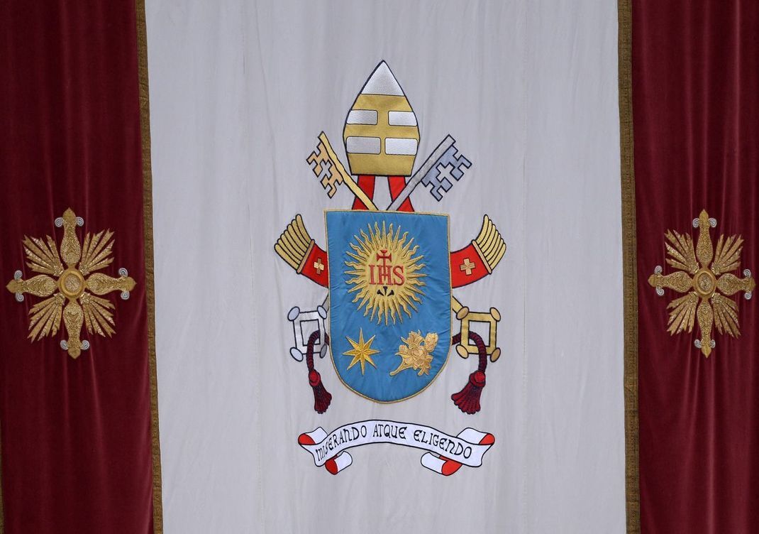 So sieht das Wappen von Papst Franziskus aus: Es besteht aus Elementen des Bischofswappens. Auch Teile des Wappens des Jesuitenordens finden sich. Franziskus war Mitglied des Ordens. 
