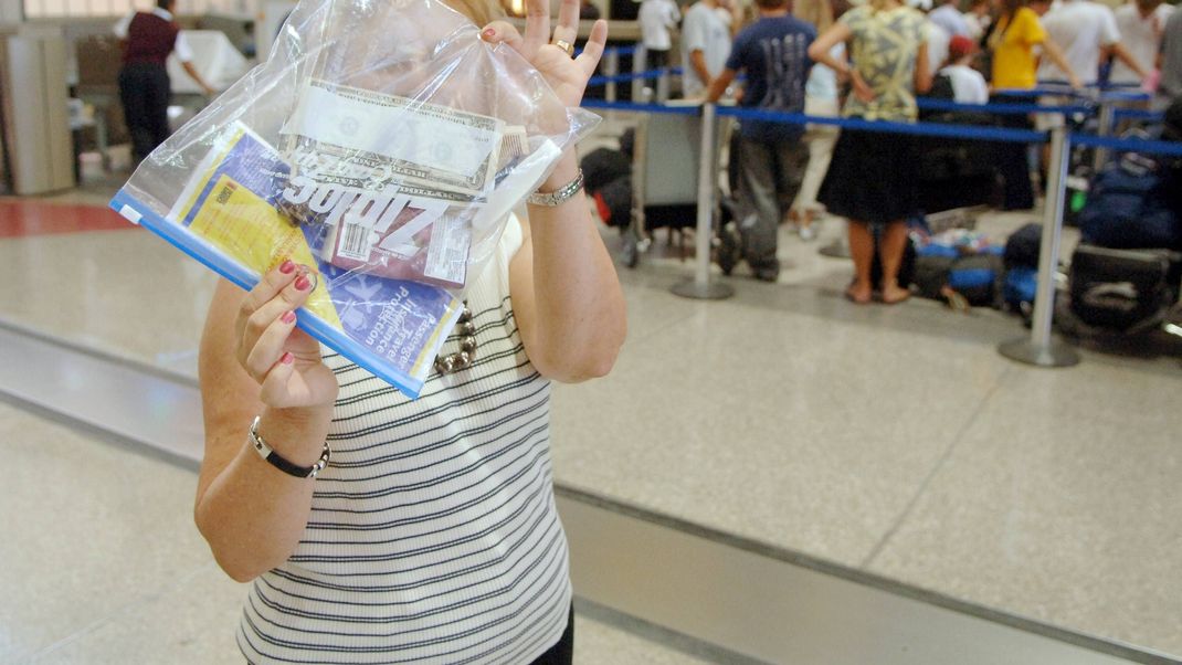 Frau mit Zip-Beutel am Flughafen