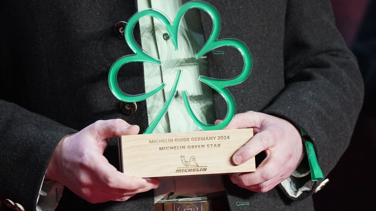 Preisträger hält einen Grünen Stern für nachhaltiges Kochen während der Verleihung der Michelin-Sterne 2024 454502068