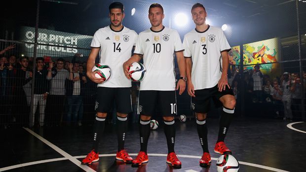 
                <strong>Deutschland (Heimtrikot)</strong><br>
                Deutschland (Heimtrikot): Die klassische Variante der Trikots für Heimspiele wurde von Emre Can (li.), Lukas Podolski und Jonas Hector (re.) vorgestellt.
              