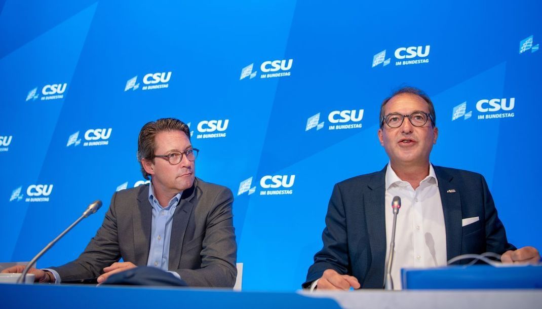 Die ehemaligen Bundesverkehrsminister Alexander Dobrindt (2013-2017) und Andreas Scheuer (2018-2021) sitzen bei einem Treffen ihrer Partei (CSU) im Jahr 2019 auf einem Podium.