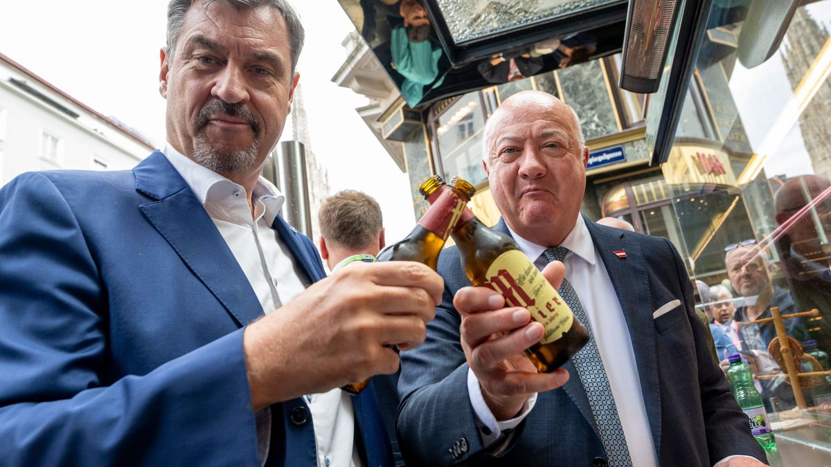Markus Söder (CSU, l), Ministerpräsident von Bayern, und Christian Stocker, Bundeskanzler von Österreich, stoßen nach ihrem Arbeitstreffen an einem Currywurststand in der Innenstadt mit Bier an.