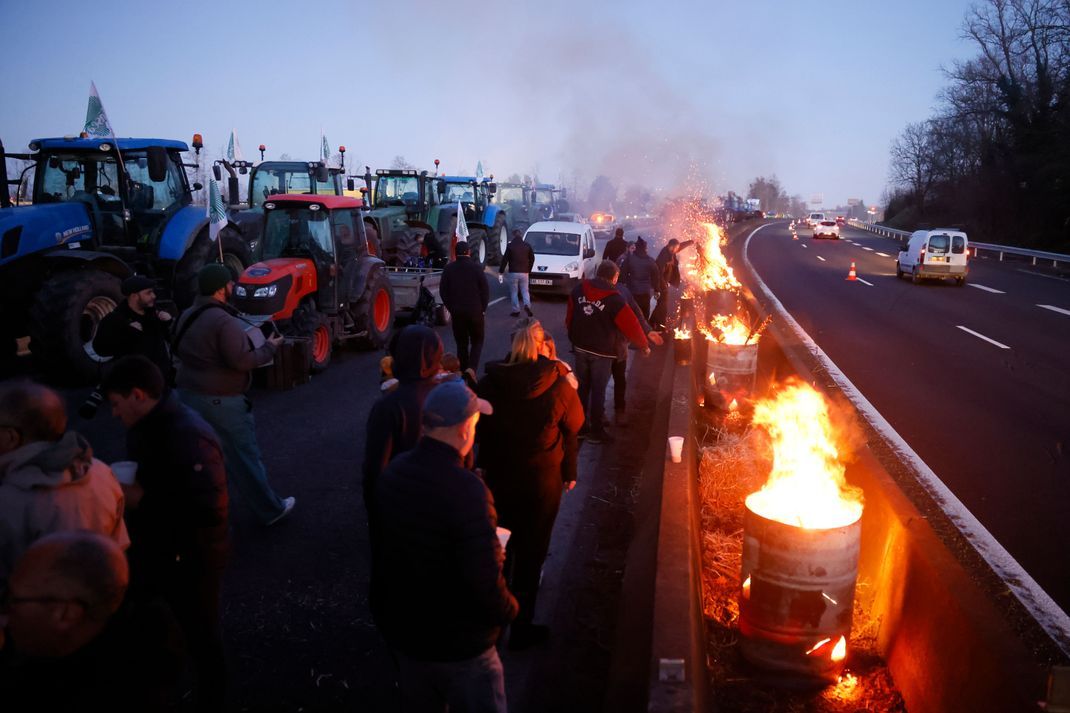 Landwirte zünden Feuer an, während sie eine Autobahn bei Ableiges nördlich von Paris blockieren.
