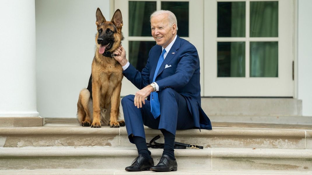 Joe Biden, Präsident der USA, sitzt mit seinem Hund Commander auf den Stufen vor dem Weißen Haus.