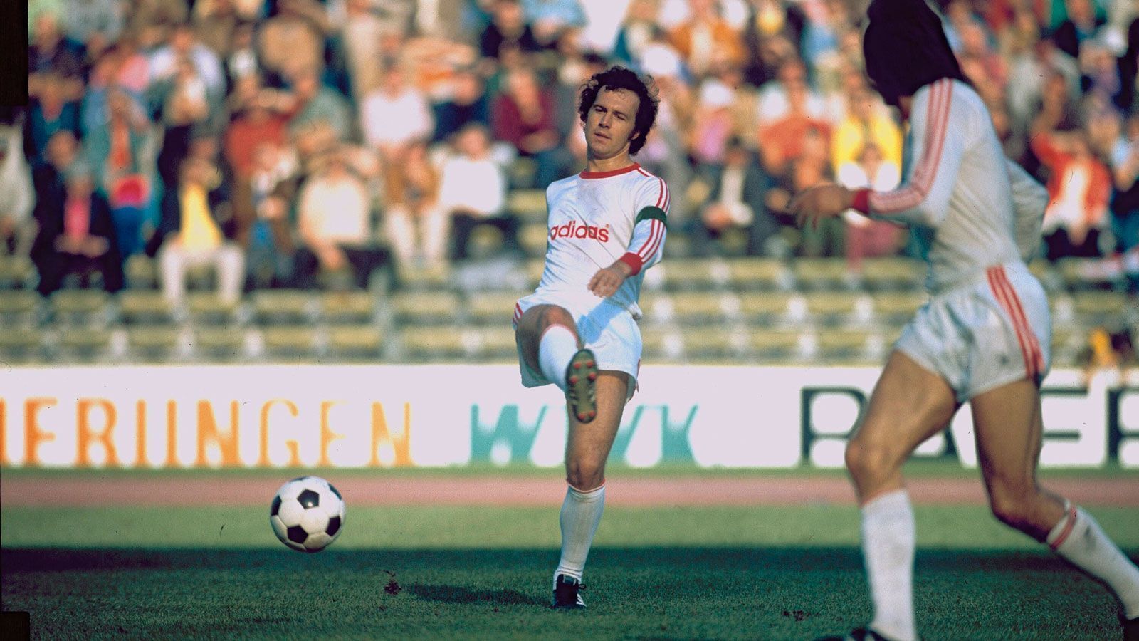 <strong>Der Außenrist-Pass</strong><br>
                Heute würde man wohl von einem Signature Move sprechen: Franz Beckenbauer mit einem seiner lässigen Außenrist-Pässe als Bayern-Kapitän, irgendwann in den 70er Jahren.
