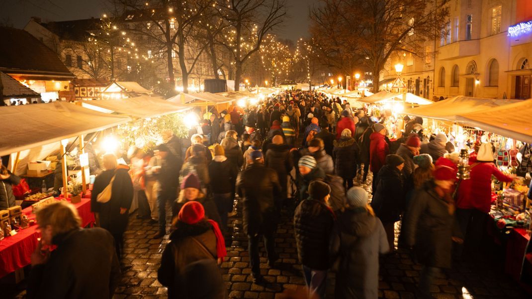 Besucher schlendern über den Alt-Rixdorfer Weihnachtsmarkt in Berlin.