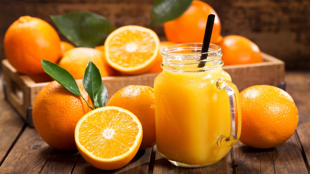 glass jar of fresh orange juice with fresh fruits