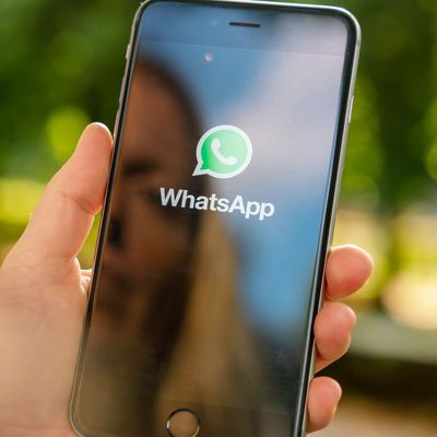 AACHEN, GERMANY AUGUST 2019: Woman holding a Apple iPhone opening Whatsapp app in a car. WhatsApp messenger for sending messages via the Internet 