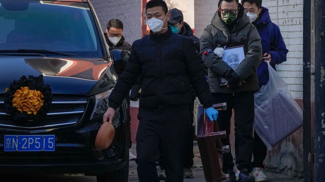 Vor einer Fieberklinik in Peking: Familienmitglieder trauern um eine verstorbene Person.