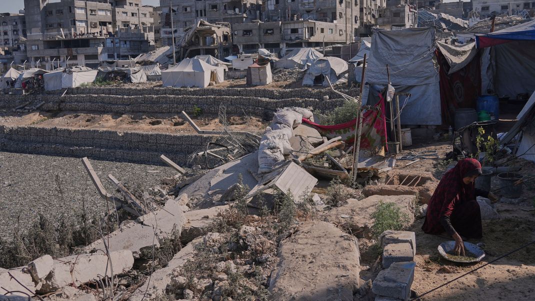Eine Frau pflanzt Samen, um Gemüse anzubauen – auf einem Gelände in einem Lager für vertriebene Palästinenser nahe einem Regenwasserspeicher, der infolge der israelischen Luft- und Bodenoffensive in Gaza-Stadt mit Abwasser und Müll verunreinigt wurde, Freitag, 18. Juli 2025.