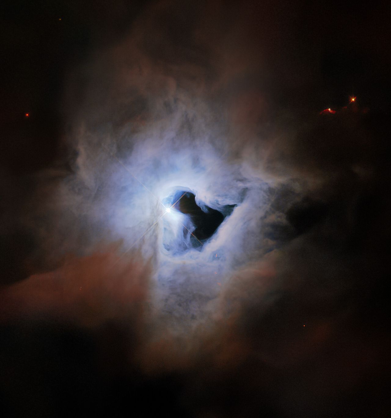 Der Reflexionsnebel NGC 1999 hat eine ganz besondere Form: Das schwarze Loch in seinem Inneren sieht aus die ein kosmisches Schlüsselloch. Der Stern V380 Orionis bestrahlt alles von hinten.